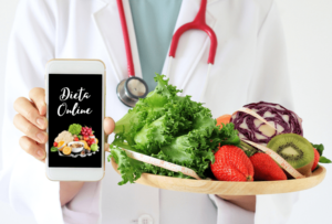 nutricionista segurando uma prato de comida saudável e mostrando no celular - emagrecerplus