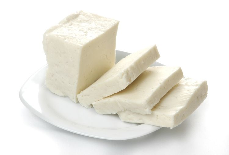 queijo branco retangular com fatias grosas em um prato branco
